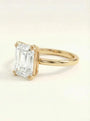 Elegantiškas emerald cut sužadėtuvių žiedas ant rankos